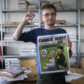 Le caricaturiste Charb, directeur de la rédaction de Charlie Hebdo, brandit le journal satirique titré "Intouchables 2" contenant plusieurs caricatures du prophète Mahomet après qu'un film américain provoque des émeutes dans le monde musulman. [Fred Dufour]