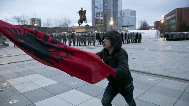 Un manifestant brandit un drapeau albanais devant le siège du gouvernement kosovare à Pristina, 24.01.2015. [Keystone/AP - Visar Kryeziu]