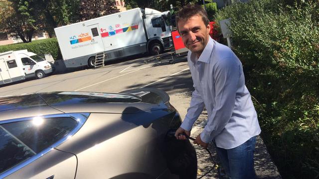 Henry Buxant "fait le plein" de la Tesla qui va le mener à Oslo. [RTS]