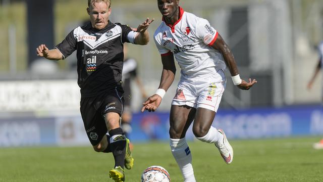 Le joueur tessinois Antoine Rey, gauche, lutte pour le ballon avec le joueur valaisan Moussa Konate. [Jean-Christophe Bott]