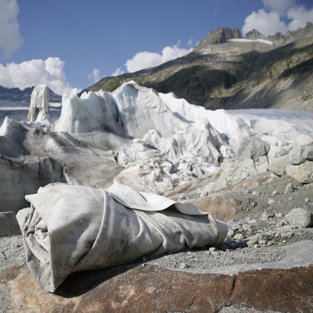 Chaque été, le glacier du Rhône doit être protégé avec des couvertures pour tenter de réduire sa fonte drastique. [Keystone - Peter Klaunzer]