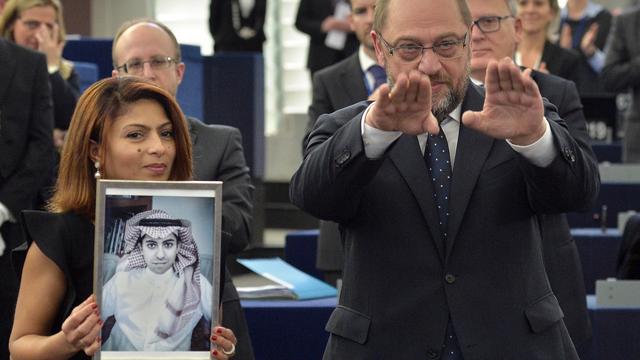 L'épouse de Raif Badaoui, tenant un portrait de son mari, aux côtés du président du Parlement européen Martin Schulz. [AFP PHOTO - Patrick Hertzog]