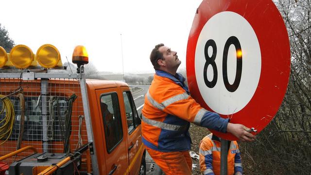 Des agents de la route mettent en place un panneau de limitation à 80 km-h (image d'illustration). [Alessandro Della Bella]