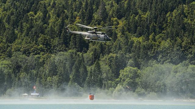 Un hélicoptère Super Puma des forces aériennes puise dans l'eau, ici en Suisse. [Jean-Christophe Bott]
