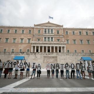 Devant le Parlement grec, de jeunes militants de gauche font campagne pour le non au référendum sur l'offre des créanciers à la Grèce, qui doit se tenir le dimanche 5 juillet. [DPA/Keystone - Socrates Baltagiannis]