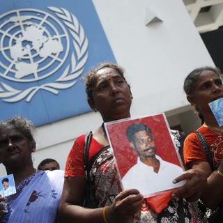 Des femmes tamoules montrent le portrait de membres de leur famille disparus durant la guerre civile au Sri Lanka. [REUTERS - © Dinuka Liyanawatte / Reuters]