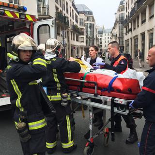 Un blessé transporté hors des locaux de Charlie Hebdo. [PHILIPPE DUPEYRAT]