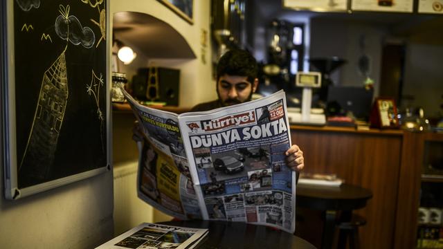 Un lecteur de Hurriyet à Istanbul, le 8 janvier 2015. La une du journal est consacrée à l'attaque des bureaux de Charlie Hebdo à Paris. [AFP PHOTO/BULENT KILIC]