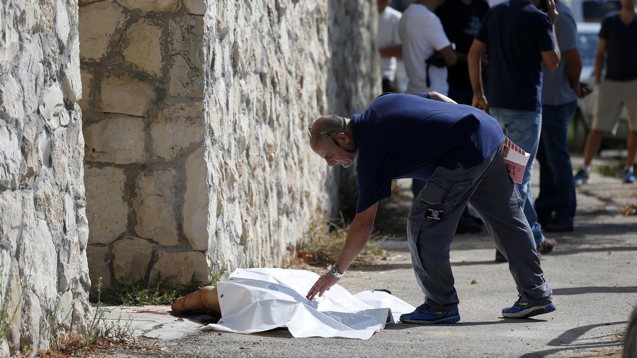 Un médecin israélien couvre le corps d'un Palestinien qui avait tenté de poignarder un soldat. [AFP Photo - Ahmad Gharabli]