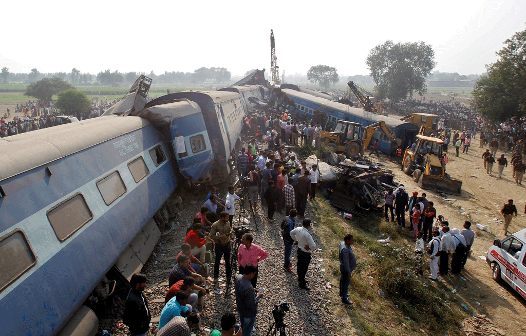 Les secours s'affairent autours du train qui a déraillé dans la nuit de samedi. [Reuters - Jitendra Prakash]