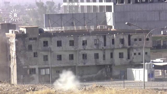 Un bâtiment de Kirkouk en proie à des combats. [Keystone - Rudaw TV via AP]