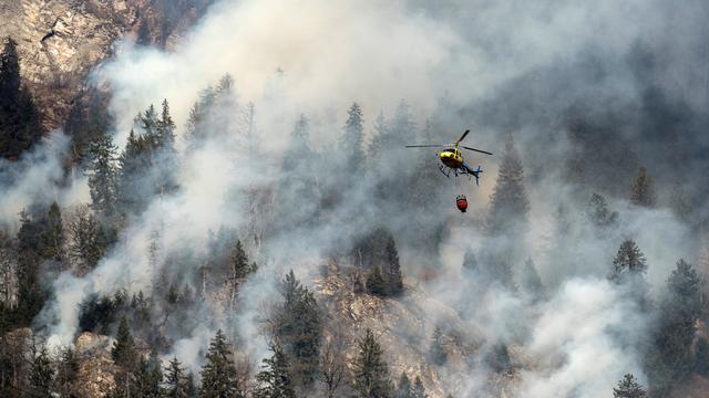 Des hélicoptères luttent contre les différents incendies qui touchent la région. [Ti-Press/Gabriele Putzu]