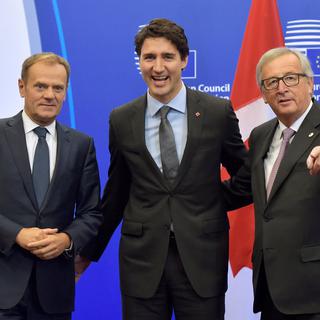 Le Premier ministre canadien Justin Trudeau, tout sourire, entouré par Donald Tusk (à gauche) et Jean-Claude Juncker. [Eric Vidal]
