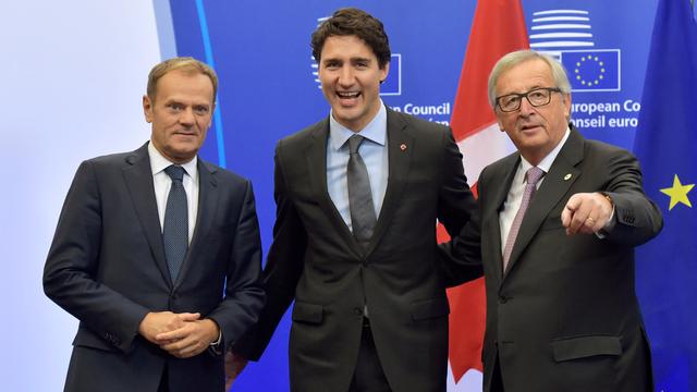 Le Premier ministre canadien Justin Trudeau, tout sourire, entouré par Donald Tusk (à gauche) et Jean-Claude Juncker. [Eric Vidal]