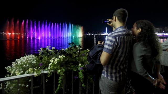 Un couple photographie une fontaine illuminée au Geneva Lake Festival 2016. [EPA/Keystone - Salvatore di Nolfi]