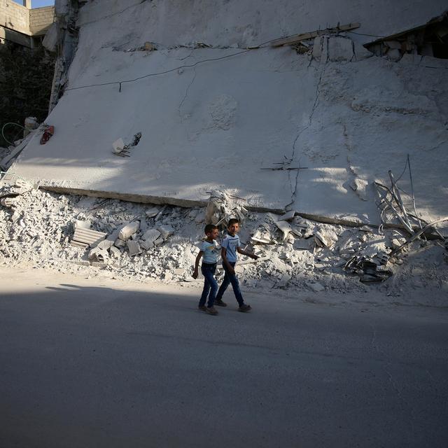 Des enfants passent devant un immeuble détruit à Douma, en banlieue de Damas. [Reuters - Bassam Khabieh]