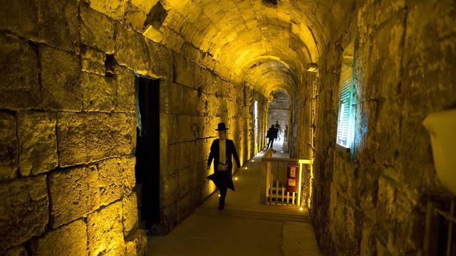 Un juif ultra orthodoxe marche dans un tunnel dans le mur ouest de la vieille ville de Jérusalem. [EPA/Keystone - Abir Sultan]