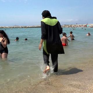 L’interdiction du burkini sur les plages françaises provoque la controverse. [AP/Keystone]