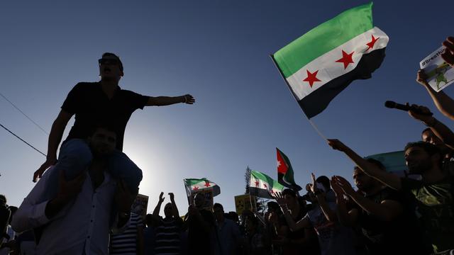 Des manifestants brandissent le drapeau de l'opposition syrienne (image d'illustration). [Muhammad Hamed]