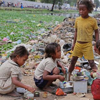 Des enfants malgaches jouent avec des bouteilles et des conserves. [Keystone - Schalk van Zuydam]