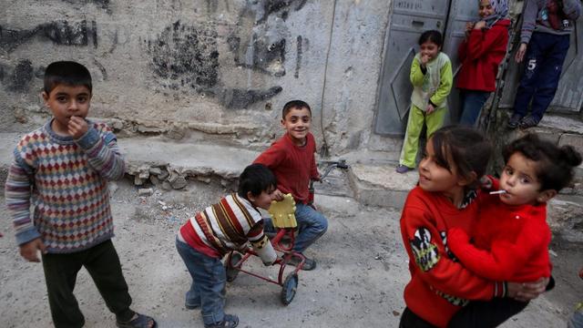 Des enfants jouent dans la rue, dans un quartier de Damas, au début de la trêve. [EPA/MOHAMMED BADRA]