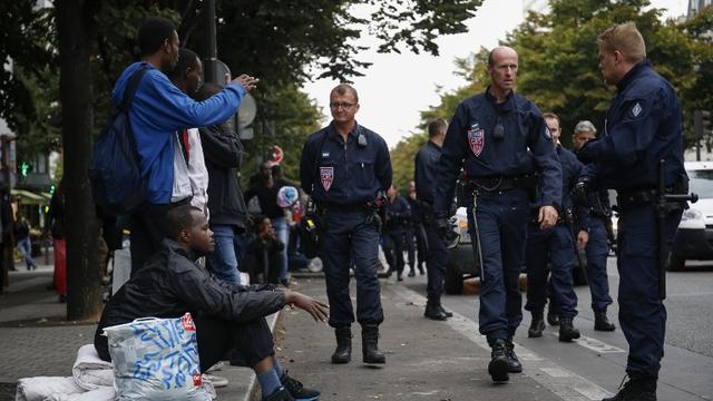 Des migrants et des policiers français lors de l'évacuation d'un campement de fortune à Paris, le 6 septembre 2016. [AFP - Matthieu Alexandre]