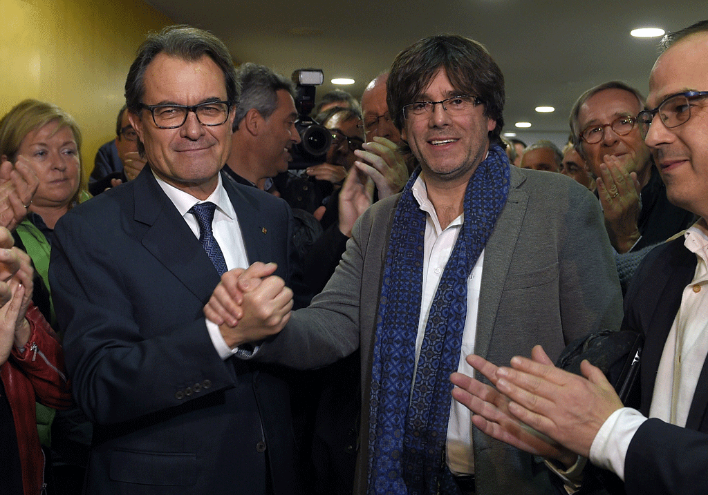 L'actuelle président de la Catalogne Artur Mas (à g.) serre la main de Carles Puigdemont (à d.). [AFP - Lluis Gene]