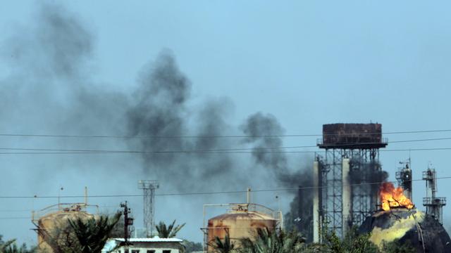 Des flammes et de la fumée noire s'élèvent au-dessus d'une usine après une attaque kamikaze, à 20 kilomètres de Bagdad.