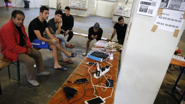 Des réfugiés rechargent leurs téléphones portables dans une structure d'accueil de Berlin, en Allemagne. [Reuters - Fabrizio Bensch]