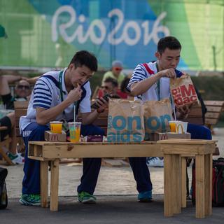 Des membres de la délégation olympique de Taipei avec un repas d'un fast food. [AFP - Ed Jones]