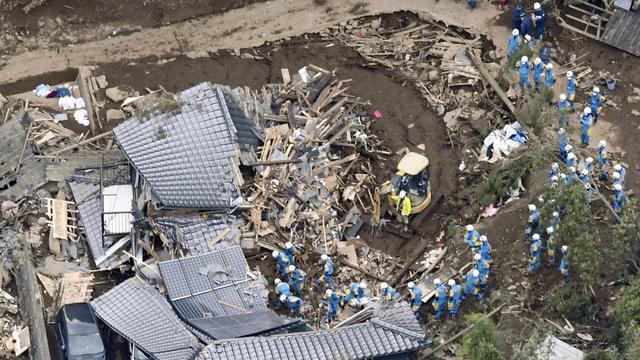 Des secouristes cherchent des personnes enterrées vivantes sous les décombres. [Kyodo News via AP]