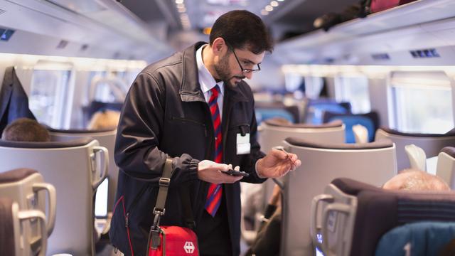 Un contrôleur des CFF dans un Eurocity reliant Zurich à Milan. [Keystone - Gaëtan Bally]