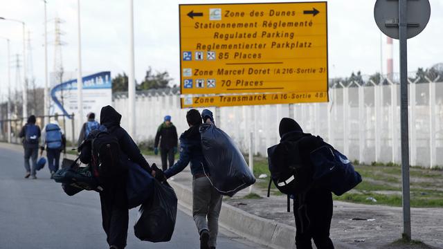 Des migrants quittent la "jungle" de Calais, leurs affaires sur le dos (photographie prise le 15 janvier dernier). [Benoit Tessier]