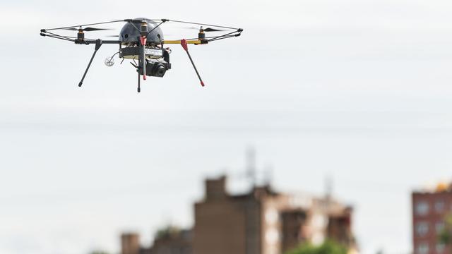 Un drone survolant un champ en Suisse. [Keystone - Christian Beutler]