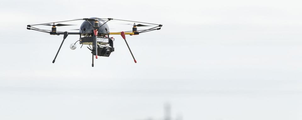 Un drone survolant un champ en Suisse. [Keystone - Christian Beutler]