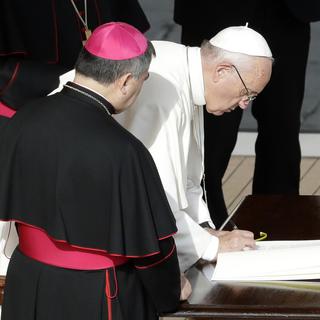 Le pape François signe un document à l'issue de la messe de clôture du Jubilé de la miséricorde, dmanche 20 novembre 2016.