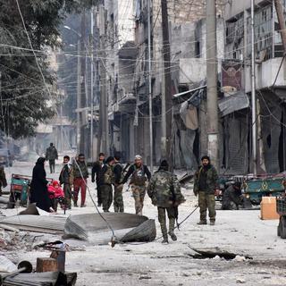 Des forces pro-gouvernementales patrouillent dans Alep-Est après avoir récupéré le quartier. [AFP - GEORGE OURFALIAN]