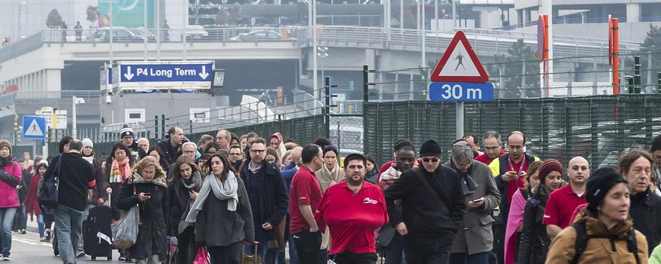 Des centaines de passagers attendent d'être redirigés, ou de recevoir des nouvelles de leurs proches. [Geert Vanden Wijngaert]