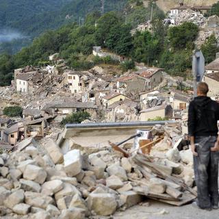 Un habitant de Pescara del Tronto regarde les dégâts provoqués par le puissant séisme qui a rasé de nombreuses maisons. [Keystone - Cristiano Chiodi]