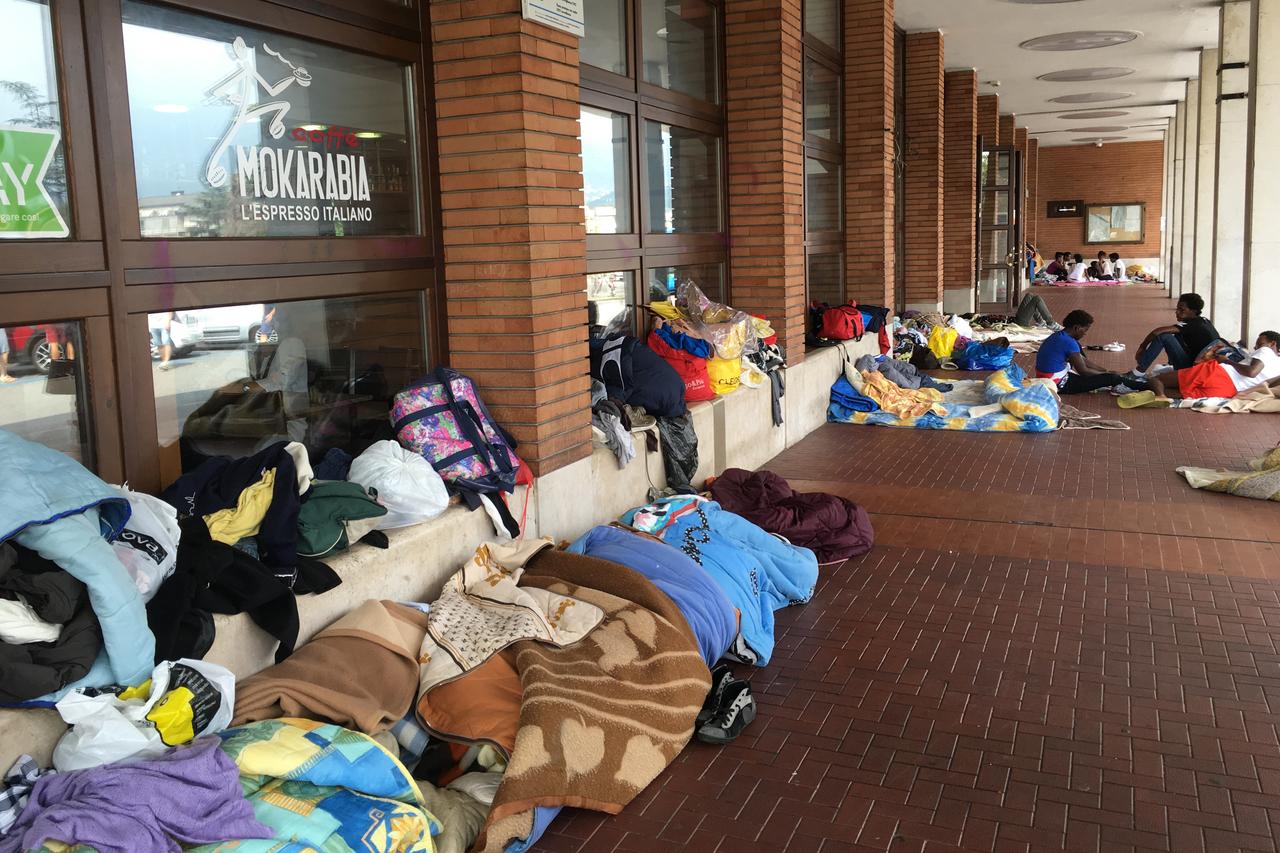 Des migrants s'abritent devant la gare. [Valentin Tombez]