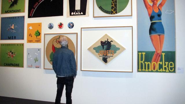 Un visiteur devant des oeuvres d'Hergé exposé au Grand Palais à Paris. [DPA/AFP - Sabine Glaubitz]