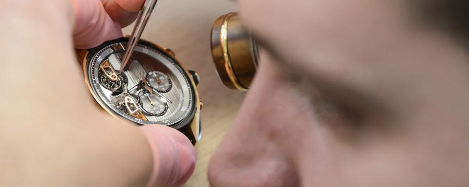 Confection d'une montre dans un atelier de La Chaux-de-Fonds. [Keystone - Jean-Christophe Bott]