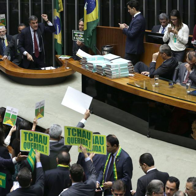 Les députés favorables à la destitution de Dilma Rousseff brandissaient des pancartes lors de la présentation de la défense de la présidente brésilienne.