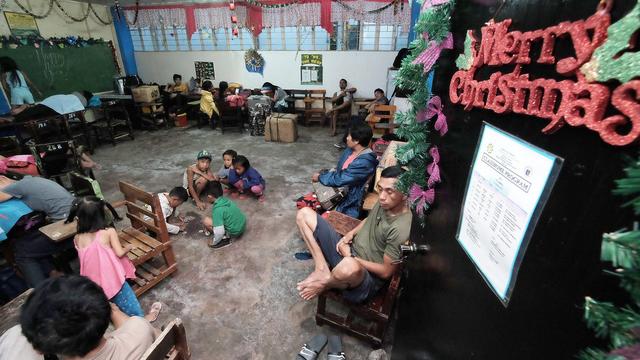 Un centre d'évacuation temporaire dans une classe d'école de Tabaco, à l'arrivée du typhon Nock-ten. [EPA - Zalrian Sayat]