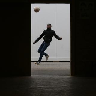 Un migrant joue au foot dans un centre de requérants à Thoune. [reu - Ruben Sprich]
