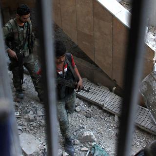 Des soldats de l'armée syrienne dans les ruines d'Alep. [AFP - George Ourfalian]
