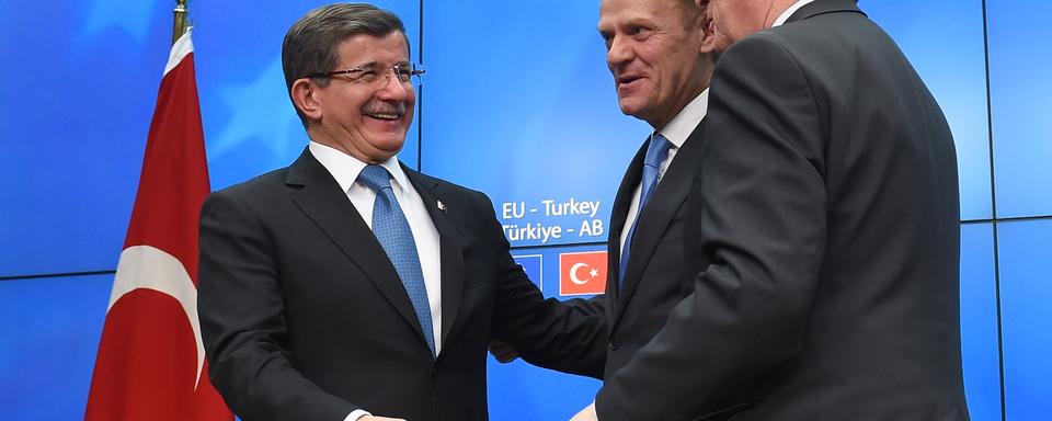 Le Premier ministre turc Ahmet Davutoglu, face au président du Conseil européen Donald Tusk et le président de la Commission européenne, Jean-Claude Juncker, au cours d'une conférence de presse, à l'issue du sommet des dirigeants de l'UE avec la Turquie, à Bruxelles, le 8 Mars 2016. [EMMANUEL DUNAND]