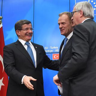 Le Premier ministre turc Ahmet Davutoglu, face au président du Conseil européen Donald Tusk et le président de la Commission européenne, Jean-Claude Juncker, au cours d'une conférence de presse, à l'issue du sommet des dirigeants de l'UE avec la Turquie, à Bruxelles, le 8 Mars 2016. [EMMANUEL DUNAND]