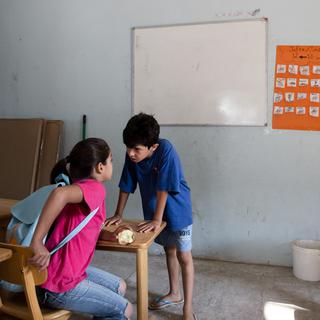 Deux enfants dans une classe improvisée du centre de réfugiés de Lagadikia. [SOOC/AFP - Konstantinos Tsakalidis]