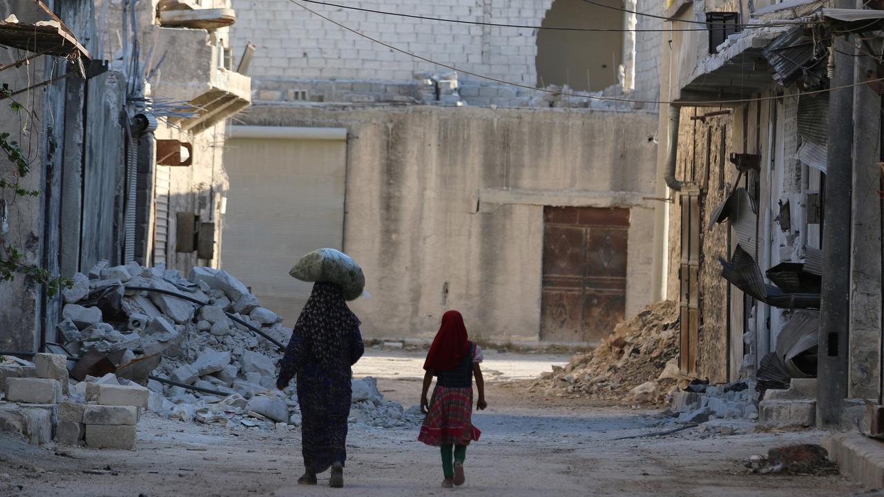 Deux civils marchent dans un quartier d'Alep tenu par les rebelles. [Abdalrhman Ismail]